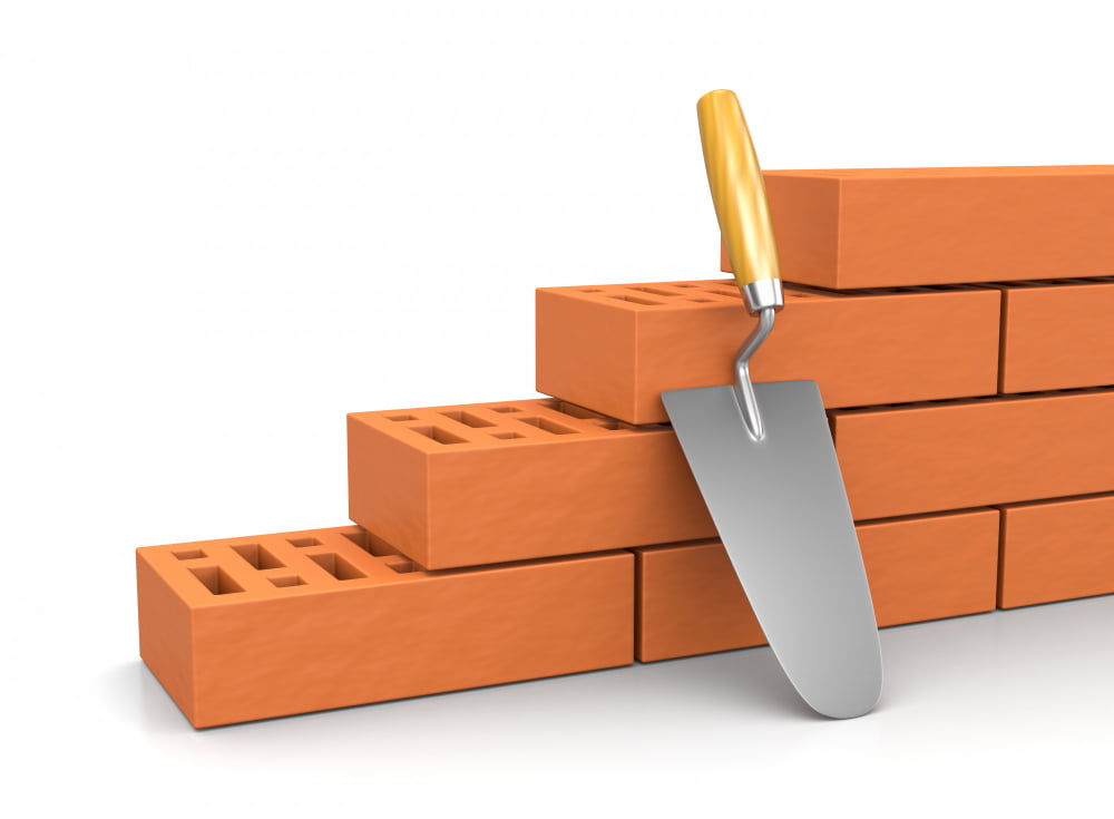 Blocos de concreto ou tijolos: Qual é o melhor para construir? 2 trowel leaned against wall