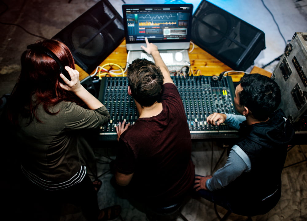 O que é preciso saber antes de contratar um estúdio de áudio? 3 group people sound mixer station 1