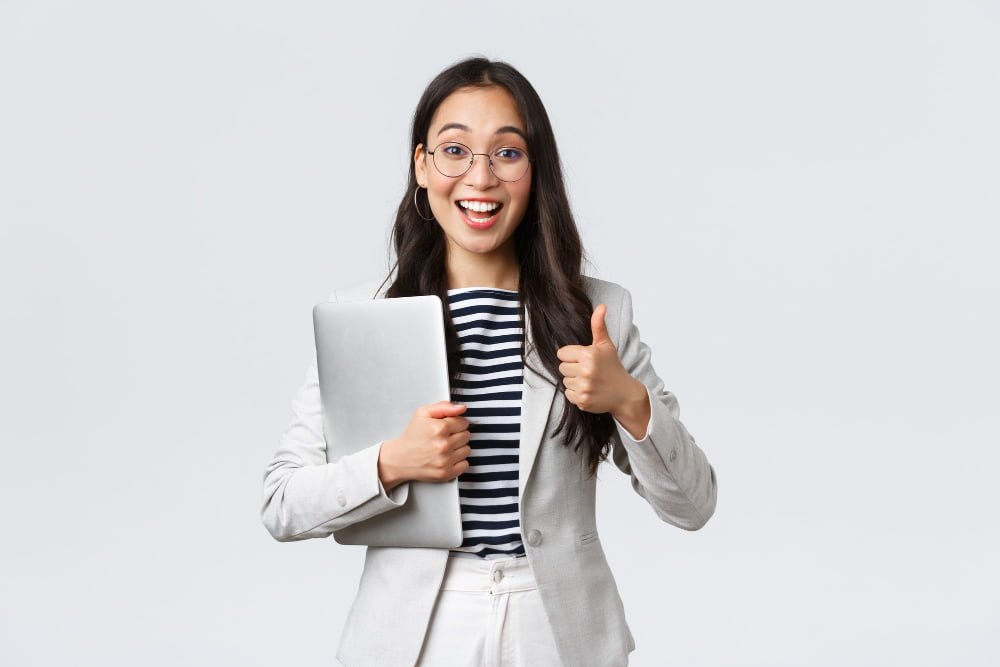 Como conseguir o certificado ISO 9001 4 business finance employment female successful entrepreneurs concept young confident businesswoman glasses showing thumbs up gesture hold laptop guarantee best service quality